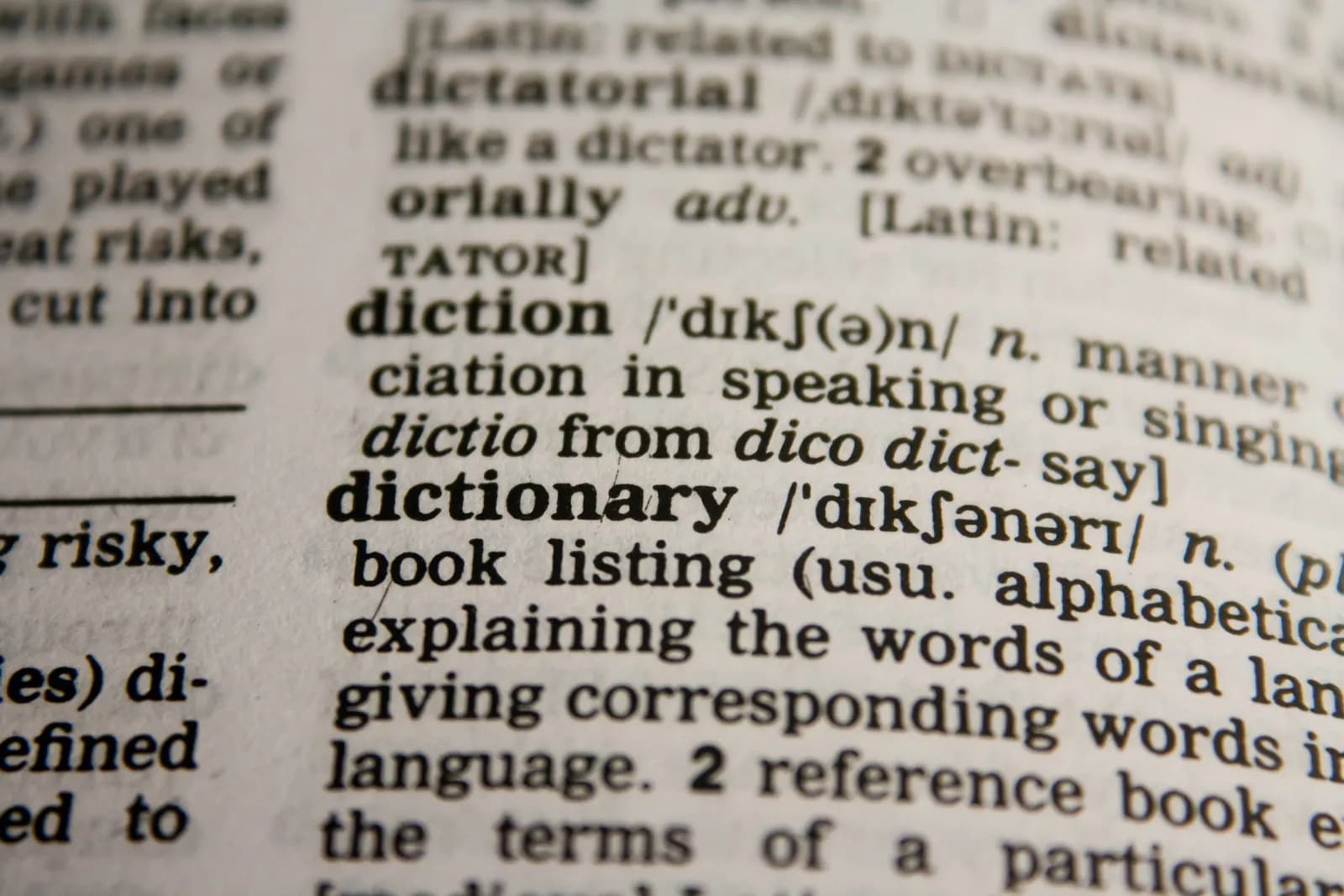 Close-up of a dictionary page with the entries for diction and dictionary in focus.