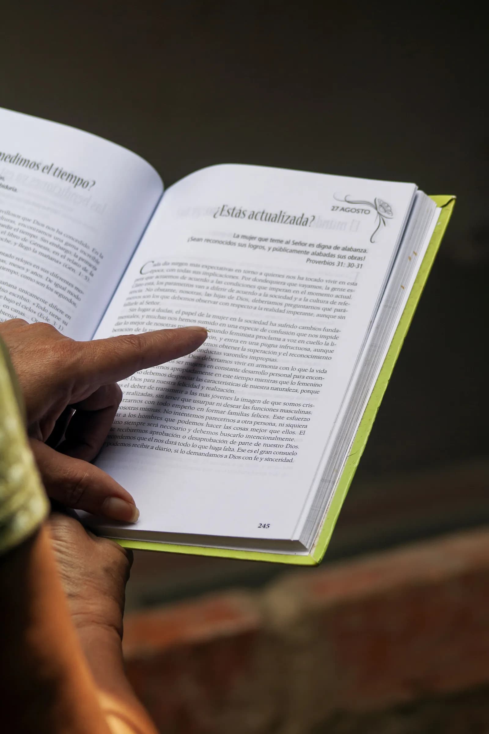 A person browsing an outdoor secondhand book and magazine stall.