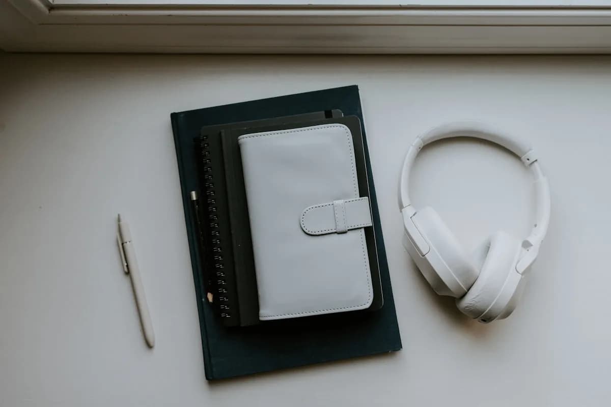Notebooks and a pair of headphones side by side, illustrating the gap between written and spoken comprehension.